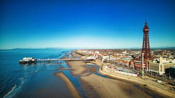 aéreo ver de Blackpool con el icónico torre, arenoso playa, y paseo en un soleado día. foto