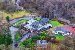 Aerial view of a luxurious estate with landscaped gardens and a winding river. photo