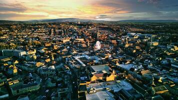 Aerial view of a city Lancaster at sunset with warm lighting, showcasing urban architecture and a distant horizon under a colorful sky. photo