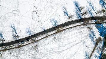 aéreo ver de un Nevado paisaje con un devanado la carretera y desnudo arboles en Harrogate, norte yorkshire. foto