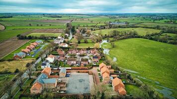 Aerial view of a quaint village surrounded by green fields and farmland, showcasing rural life and landscape. photo