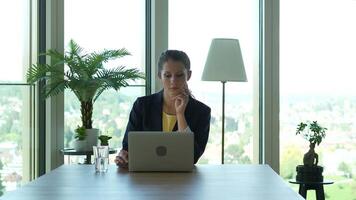 fêmea o negócio pessoa trabalhando em computador portátil computador escrivaninha dentro cidade escritório video