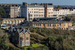 Elegant historical buildings on a hillside with lush greenery in a quaint urban landscape in Bristol. photo