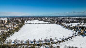 aéreo ver de un Nevado paisaje con un la carretera divisor urbano y rural areas debajo un claro azul cielo en Harrogate, norte yorkshire. foto