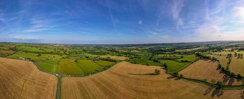 Panoramic aerial view of lush green countryside with fields and a clear blue sky. photo