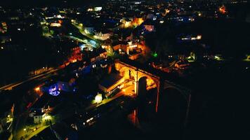 Aerial night view of a cityscape with illuminated streets and buildings, showcasing urban nightlife in Knaresborough, North Yorkshire photo