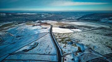 a view of a snowy road and a plane flying over it photo