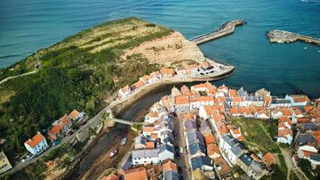 Aerial view of a coastal village with a marina, surrounded by water and cliffs in Staithes, England. photo