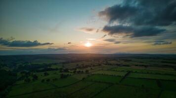 Aerial view of a lush countryside at sunset with vibrant green fields and a dramatic sky in Yorkshire. photo