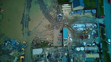Aerial view of a flooded industrial area with submerged vehicles and buildings. photo