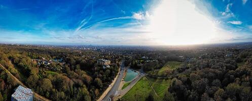 Panoramic aerial view of a lush green landscape with a road under a bright blue sky with wispy clouds. photo