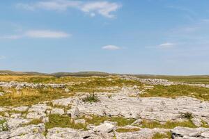 Limestone pavement landscape under a clear blue sky, showcasing unique geological formations. photo