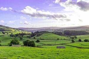 Scenic landscape photo in Yorkshire Dales with clouds and sun
