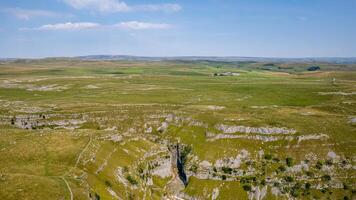 Aerial view of a vast, green limestone karst landscape under a clear blue sky. photo