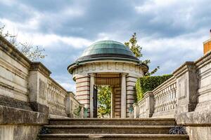 Classical stone gazebo with steps under a cloudy sky. photo