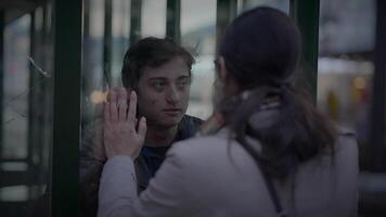 verdrietig moeder gezegde tot ziens naar zoon Bij trein station staand achter venster glas video