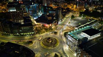 aéreo noche ver de un paisaje urbano con iluminado calles y rotonda, exhibiendo urbano tráfico y arquitectura en leeds. foto