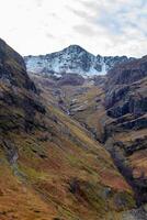 Majestic mountain landscape with snow-capped peaks and autumnal valley in Scotland. photo