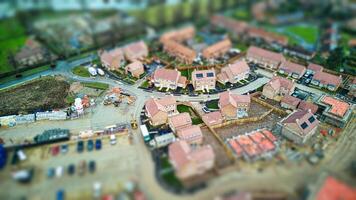 Aerial view of suburban neighborhood with tilt-shift effect, highlighting residential houses and construction area. photo