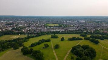 Aerial view of a suburban landscape with green parks and residential areas under a hazy sky in London. photo