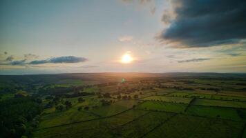 Aerial view of a lush landscape at sunset with vibrant skies and patchwork fields in Yorkshire. photo