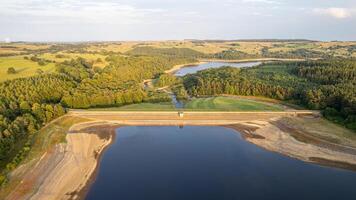 Aerial view of a serene lake with surrounding greenery and a clear sky. photo