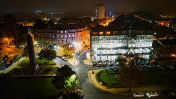 Noche paisaje urbano con iluminado edificios y calles, exhibiendo urbano arquitectura y tráfico en Harrogate, norte yorkshire. foto