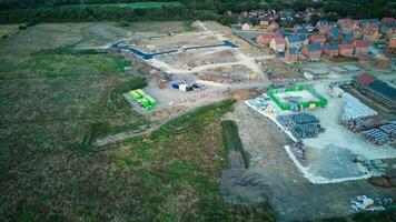 Aerial view of a construction site with materials and machinery near a residential area at dusk. photo