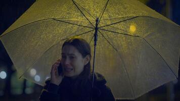 infeliz preocupado fêmea pessoa chorando enquanto chamando segurando guarda-chuva video