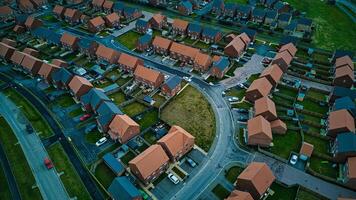 Aerial view of a suburban neighborhood at dusk with rows of houses and a central roundabout. photo