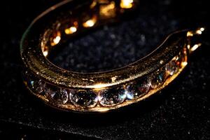 elegante oro pulsera con espumoso diamantes en un oscuro, reluciente antecedentes. foto