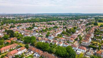 Aerial view of a suburban neighborhood with rows of houses and green trees under a cloudy sky in London. photo