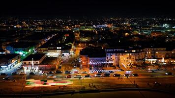 paisaje urbano a noche con iluminado calles y Moviente vehículos, exhibiendo urbano la vida nocturna y tráfico en piscina de fondo, Inglaterra. foto