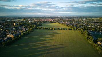 aéreo ver de un lozano verde paisaje a amanecer con un pueblo en el distancia debajo un suave azul cielo con dispersado nubes en Harrogate, norte yorkshire. foto