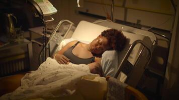 joven africano madre acostado en hospital cama participación recién nacido bebé después nacimiento video