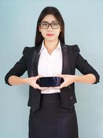 Young women in suit holding her smartphone photo