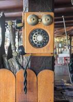 Vintage telephone hang on wooden pole photo