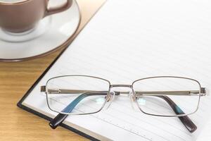 Eyeglasses put on note pad open blank page photo