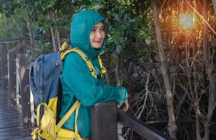 Asian woman standing on the wooden sidewalk relaxing travel nature in the mangrove forest resting on holiday vacation together,lifestyle travel concepts. photo