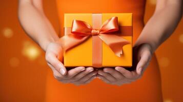 AI generated Woman's hands hold an orange gift box with a bow and ribbons on a colorful backdrop. Ai Generated photo