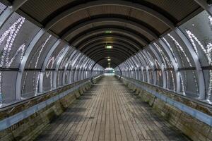 sendero y pasarela canal un túnel terminado el la carretera y ferrocarril desde el hilversum medios de comunicación parque a el cerca tren estación. foto