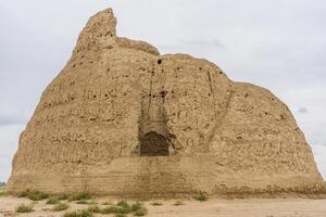 An ancient ice chamber build from clay used as refrigerator in Old Merv, Mary, Turkmenistan on a clouded background photo