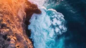 AI generated Spectacular drone view captures an ocean wave crashing on a rocky cliff, with a sunset horizon backdrop. Ai Generated. photo