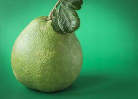 un verde pomelo Fruta con hojas en eso foto