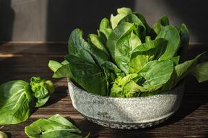a bowl of spinach on a table photo