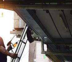 The technician is spraying water to clean the air conditioner. photo