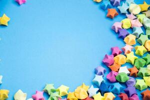 Paper folded into the shape of a multi-colored 5-pointed star, on a blue background. photo