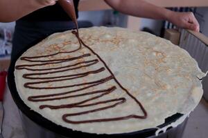 Crepe and chocolate cream line grilling on hot plate. photo