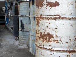 antiguo petróleo tanques hecho desde oxidado metal son arreglado en filas desde el orden en cuales ellos fueron usado en un industrial planta. foto