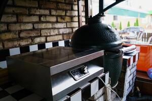 kitchen of the restaurant is equipped with an expensive ceramic grill oven and an electric stove near the window. Close-up photo